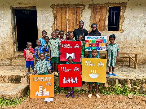 Young Growers Club members holding No Poverty, Zero Hunger and Quality Education signs
