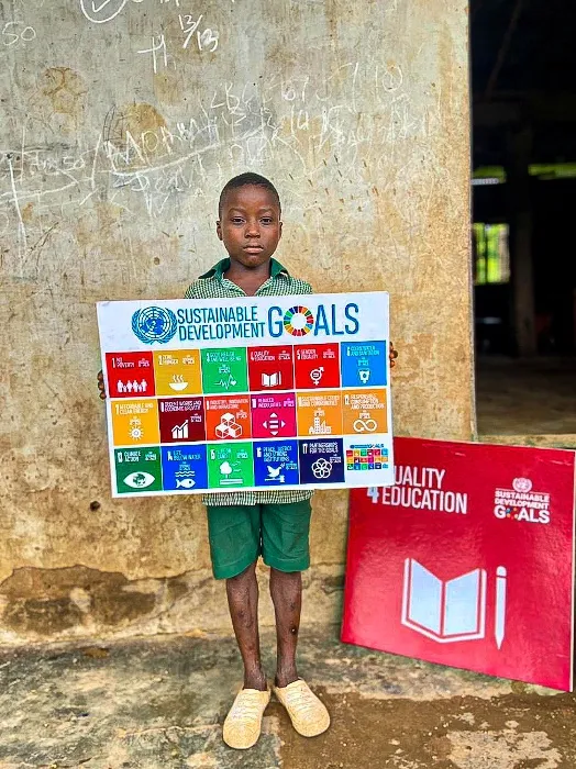 Young Growers Club pupil holding the Sustainable Development Goals poster